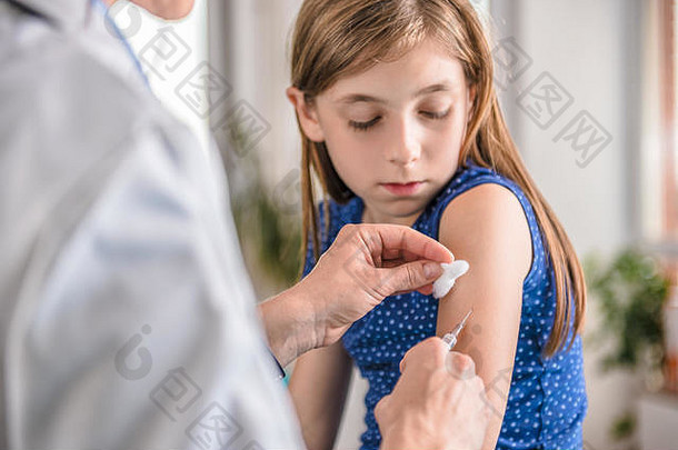 儿科女医生给一个小女孩手臂注射疫苗