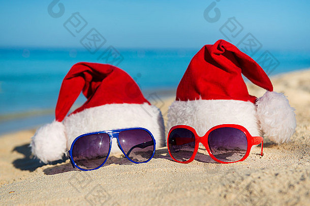 圣诞节假期和浪漫的海上<strong>新年</strong>。沙滩上的圣诞老人帽子和太阳镜