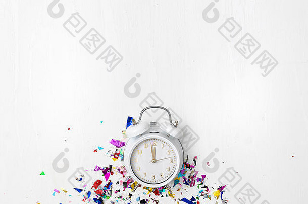 白色背景的闹钟，带有不同颜色的新年物品