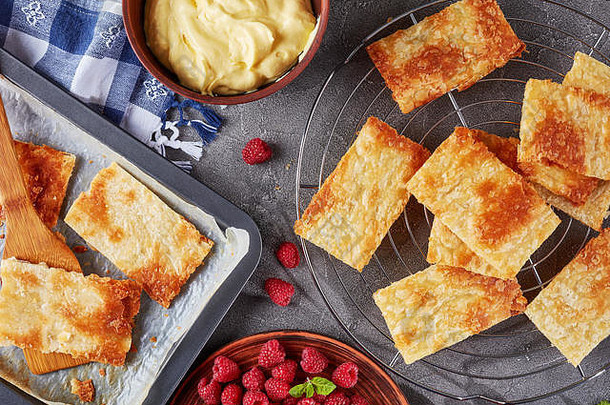 新鲜烤部分泡芙糕点烘焙表烹饪法国甜点millefeuille新鲜的成熟的树莓板奶油碗