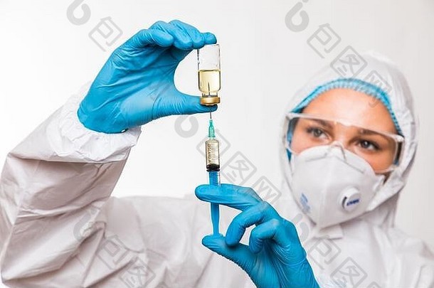 2019冠状病毒疾病的医生、护士或科学家用蓝色腈手套感染流感、麻疹、冠状病毒CVID-19疫苗。