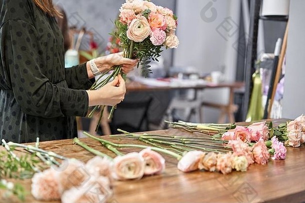 女花匠在花店创造美丽的花束。在花店工作。送花。