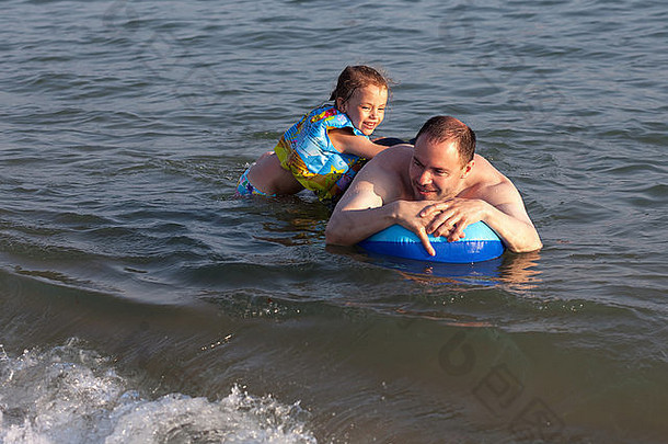 一名男子和女儿在海上乘坐充气筏。