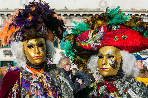 在威尼斯狂欢节上，一对身着盛装、戴着面具的情侣。