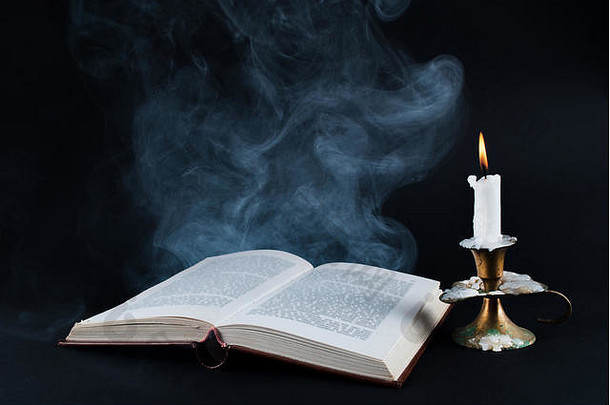 烟书蜡烛燃烧烛台黑暗黑色的背景