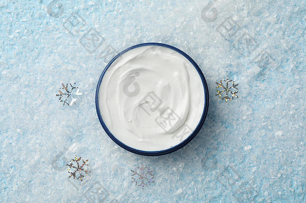 雪蓝背景上的一罐冬季护肤霜，文本空间。俯视图
