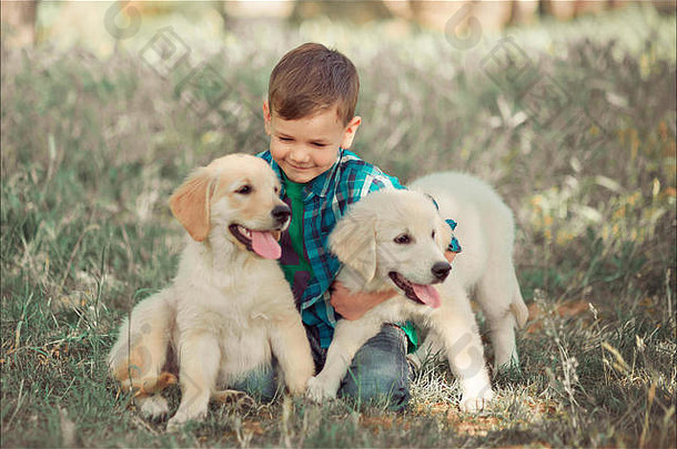 可爱英俊的男孩，蓝眼睛的少年，在户外玩耍，令人惊异的白色粉色拉布拉多猎犬，享受夏日阳光明媚的假期周末，尽情玩耍