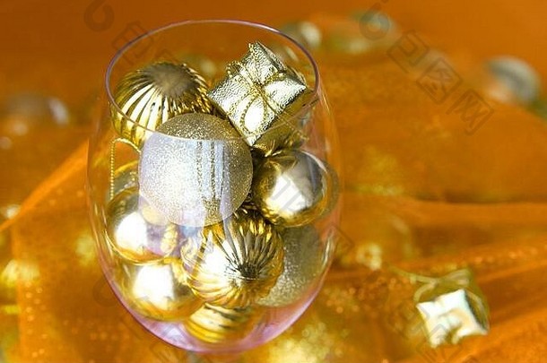 金色和黄色的圣诞背景，内有葡萄藤玻璃和金色圣诞装饰品。圣诞装饰藤蔓玻璃