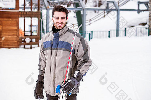 站在雪地上滑雪的英俊男子