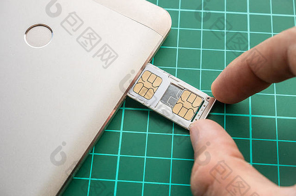 SIM卡托盘，装满Nano SIM卡和Micro SIM卡，用手推