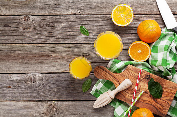 木桌上放着新鲜成熟的橙子和<strong>果汁</strong>。具有空间的俯视图