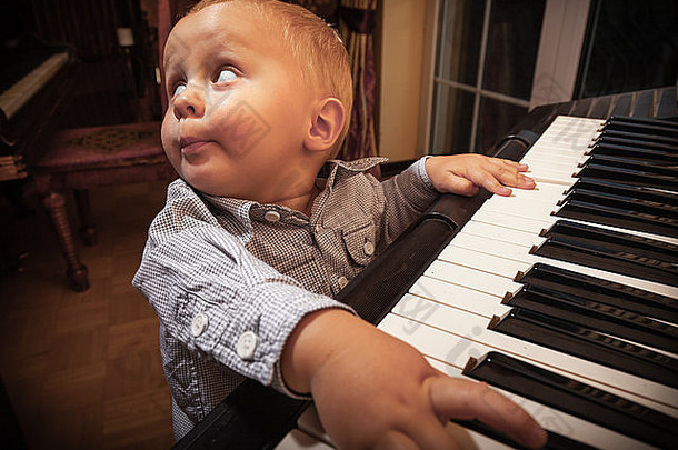 快乐的童年和音乐。小男孩在黑色数字midi键盘上弹奏钢琴合成器乐器