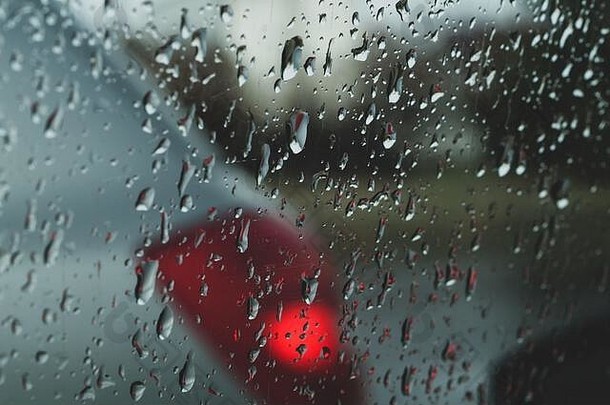 玻璃上的雨滴。透过车窗观看。大雨。透明表面上有水滴的抽象背景