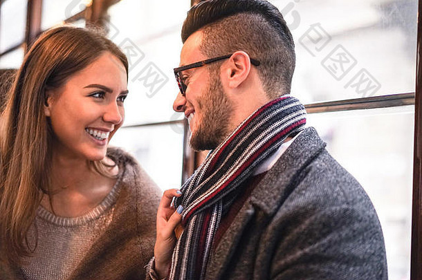 一对幸福的夫妇在<strong>公交车上</strong>面面相觑地笑着——年轻漂亮的女人拉着她男朋友的围巾在身边——爱，浪漫的概念