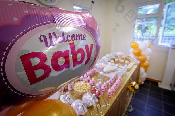 欢迎气球，背景是装饰品和食物桌