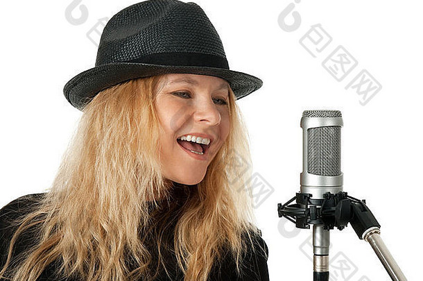 戴黑帽子的女歌手用录音室麦克风<strong>唱歌</strong>。在白色背景上隔离。