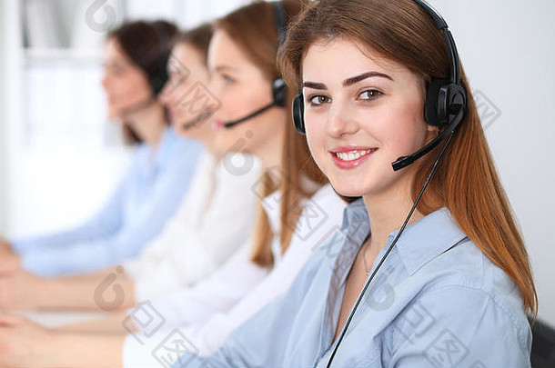 呼叫中心。美丽、欢快、微笑的运营商使用耳机咨询客户。客户服务的经营理念