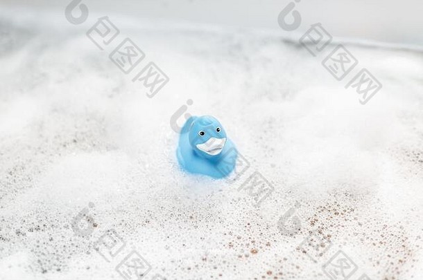 蓝色橡胶鸭在泡沫浴缸里游泳