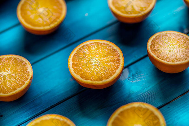 橙色在一张蓝色的桌子上切下新鲜的橙子。