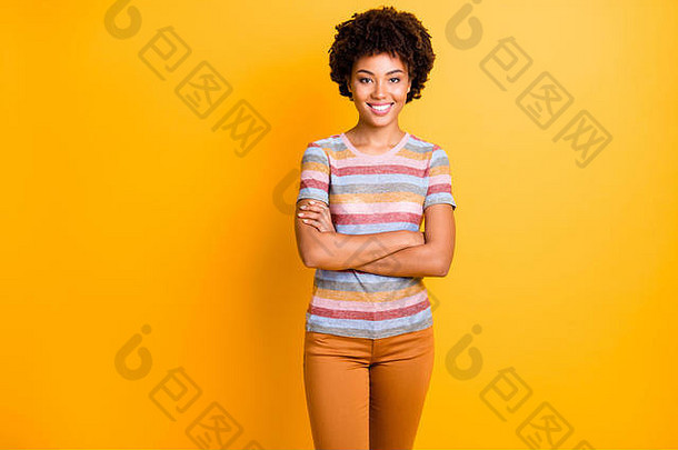 令人惊叹的深色皮肤商务女士双臂交叉准备上班的照片穿着黄色隔离的休闲条纹t恤和长裤
