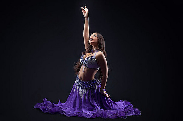 美年轻的女孩跳舞紫色的面纱阿拉伯语风格服装黑暗