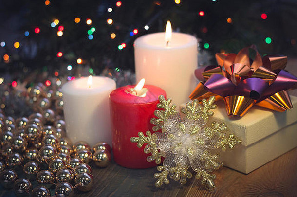 燃烧着蜡烛、圣诞装饰品和礼品盒的静物画