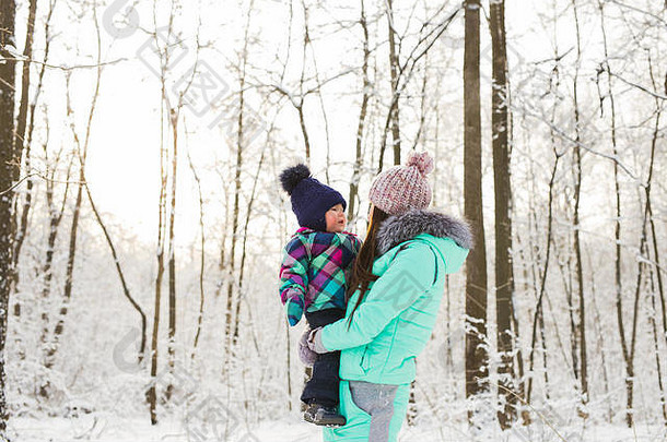 祝妈妈和宝宝在<strong>冬季</strong>公园快乐。家庭户外活动。快乐的妈妈带着她的孩子