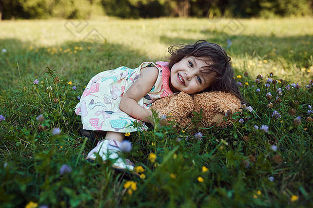 可爱的微笑婴儿女孩拥抱软熊玩具