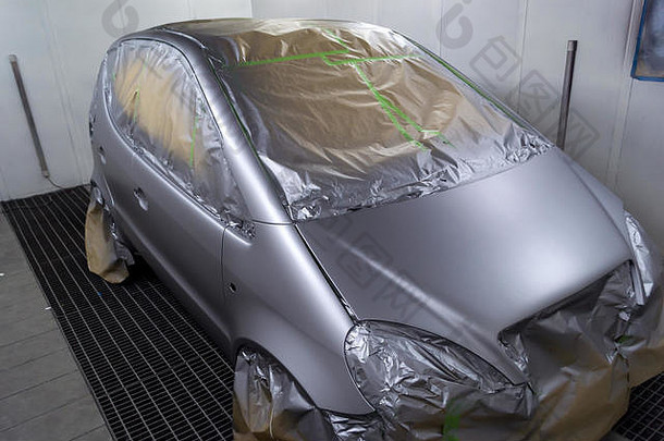 掀背车后部的银色汽车的完整绘画，其中一些部分由纸张保护，以防车身上的油漆滴飞溅