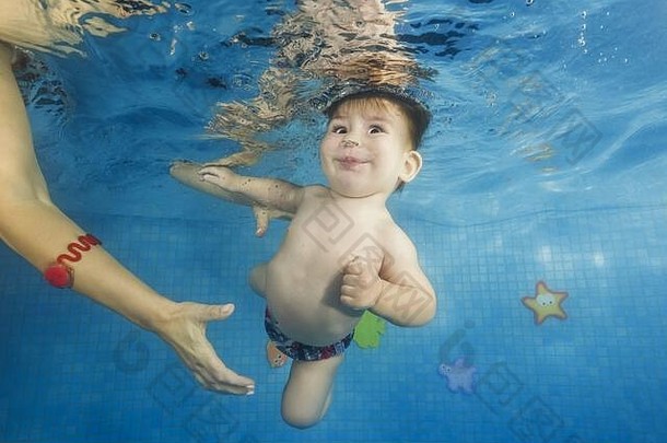 小<strong>男孩</strong>在游泳池里学习水下游泳