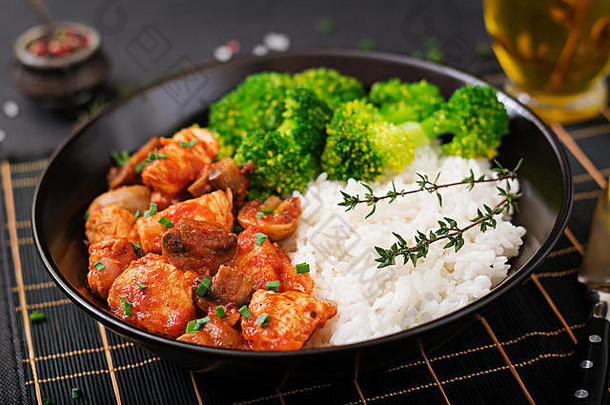 番茄汁炖蘑菇鸡柳，配煮熟的西兰花和米饭。适当的营养。健康的生活方式。饮食菜单。