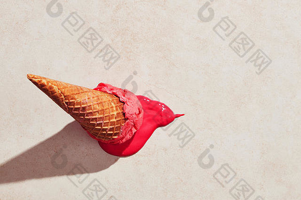 草莓冰淇淋和华夫蛋卷掉在地板上，在炎热的夏日阳光下融化在地上。平面视图