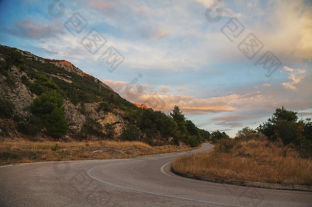 蜿蜒的道路在山与山之间转弯，在夏季日落时到达山顶