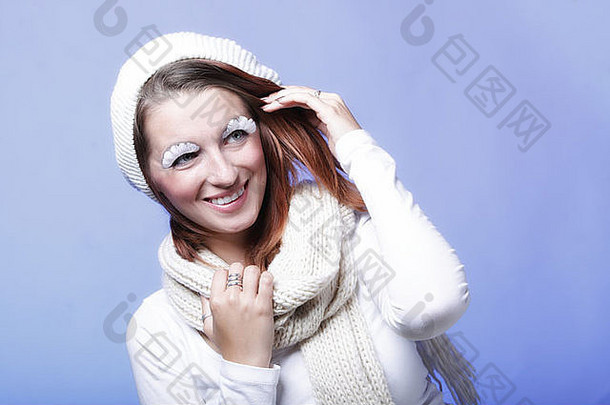 冬季时尚美女穿着保暖服装时尚创意化妆假长白眼睫毛蓝色背景
