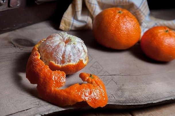 几个完整的新鲜柑橘或柑橘、柑橘、克莱门汀、柑橘类水果和一个水果在木板上半去皮