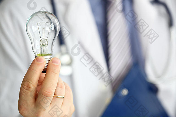 男医生手握灯泡作为光明创意发明的象征