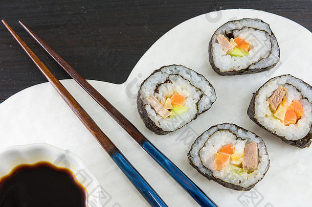 寿司卷和木制筷子放在心形盘子上