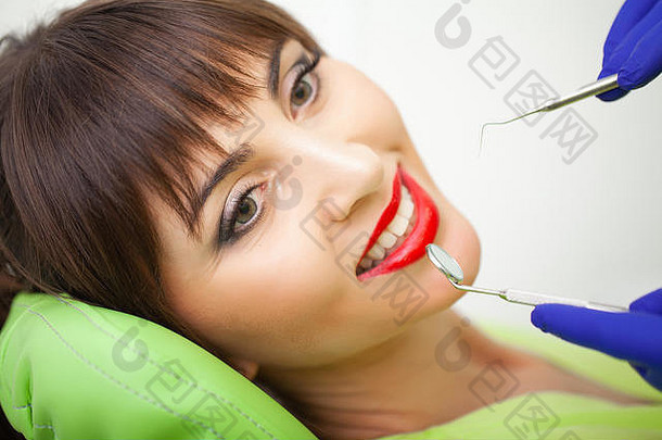年轻女患者到牙科诊所就诊。在牙医处检查牙齿的妇女