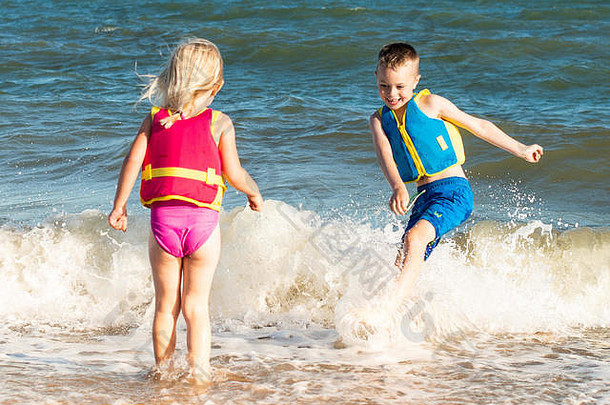 一个患有多动症、自闭症、阿斯伯格综合症的英俊男孩在一个美丽的夏日和他的妹妹一起游泳，在海里泼水，精力充沛，