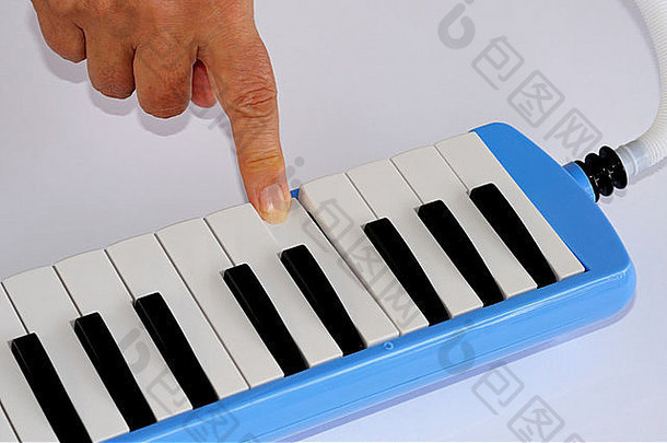 蓝色和白色钢琴吹奏器，手指按中C。