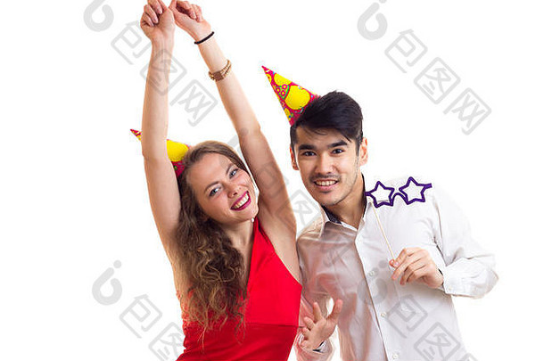 一对年轻夫妇拿着卡片棒和庆祝帽子