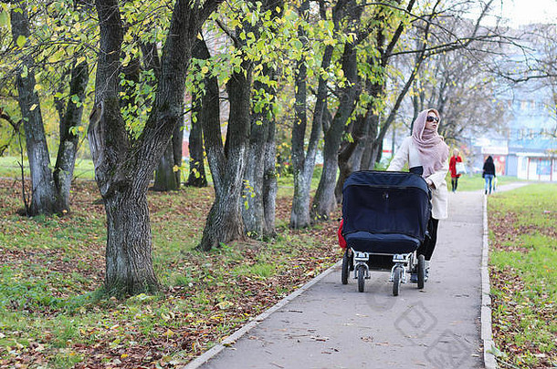 带着婴儿车在公园里的女孩