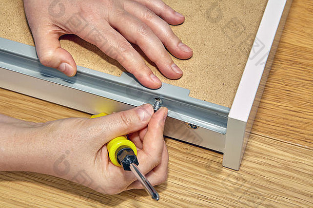 抽屉时使用家具紧固件，家具制造商的手可以特写。