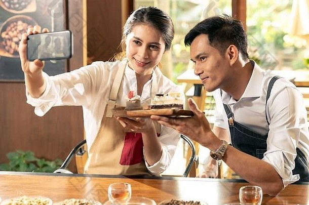 两位年轻亚洲老板的博客写手的自拍大便企业家评论咖啡厅咖啡厅的社交媒体和在线营销。用于st