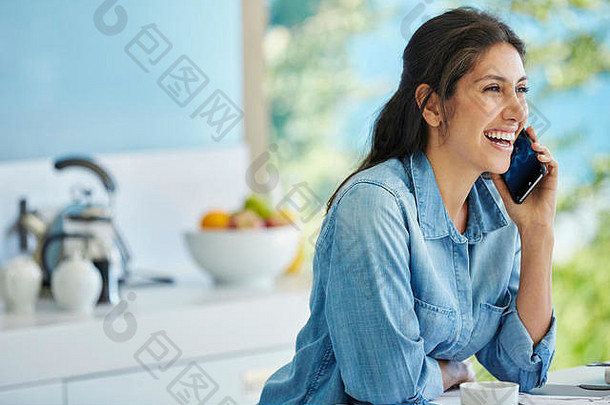 微笑的女人在厨房打手机