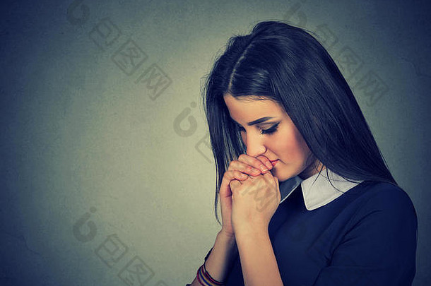 悲伤的年轻女子闭着眼睛祈祷的特写照片
