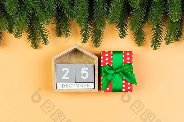 彩色背景上木制日历、礼品盒和枞树的俯视图。十二月二十五日。圣诞节的时候有复印空间。