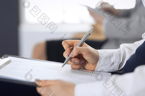 商务人士在办公室参加会议或培训，特写。坐在椅子上做笔记的女人，比如排队或开会