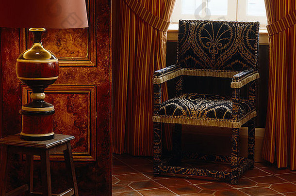 灯木凳子黑色的黄金软垫椅子布盖框架前面窗口红色的条纹窗帘