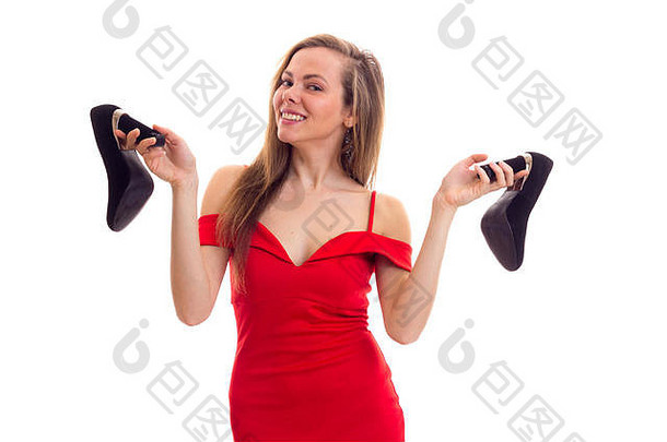 年轻的女人红色的衣服持有鞋子